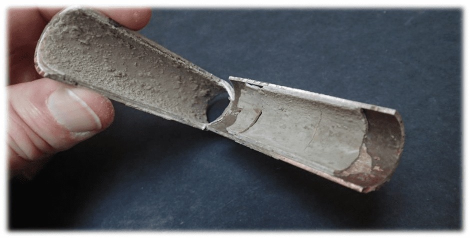 Поперечное сечение трубки теплообменника с многослойными отложениями накипи и шлама